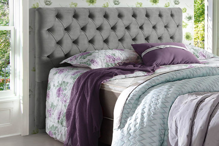 cama posta com roupa de cama em tons de lilás
