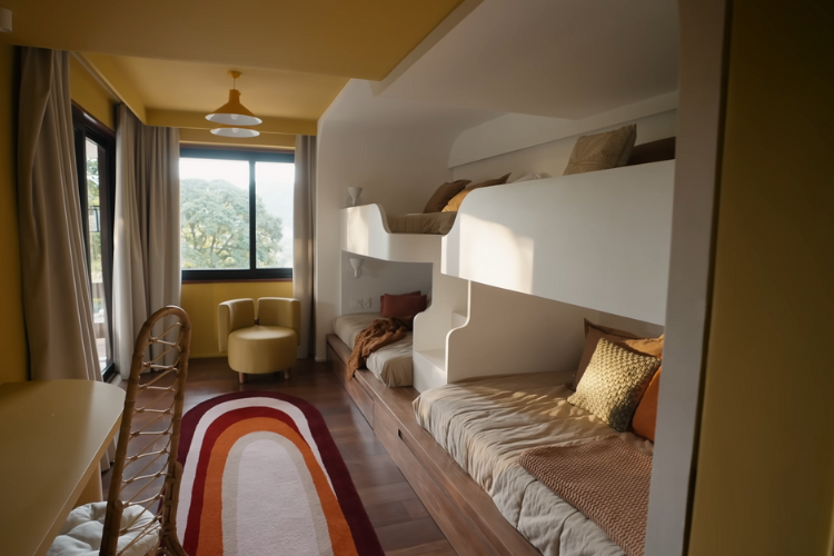 Beliches planejadas com roupas de cama e tapete de cores quentes.