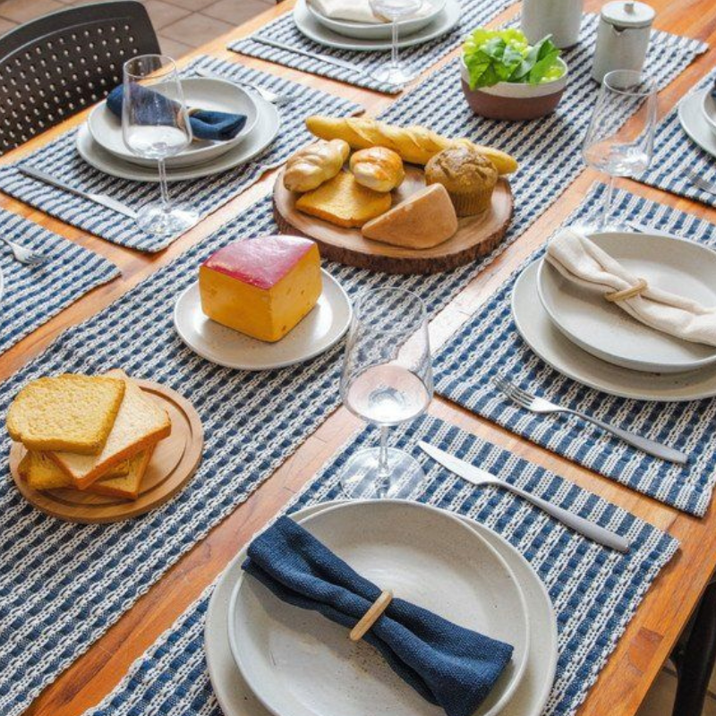 Mesa posta com jogo americano listrado com azul