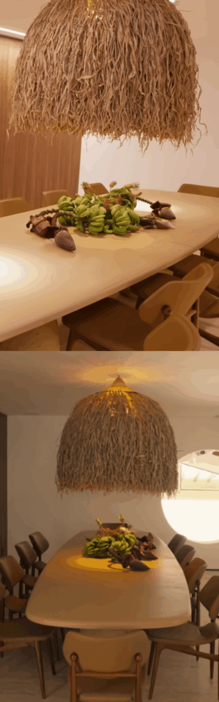Mesa de jantar de madeira longa com lustre de palha.